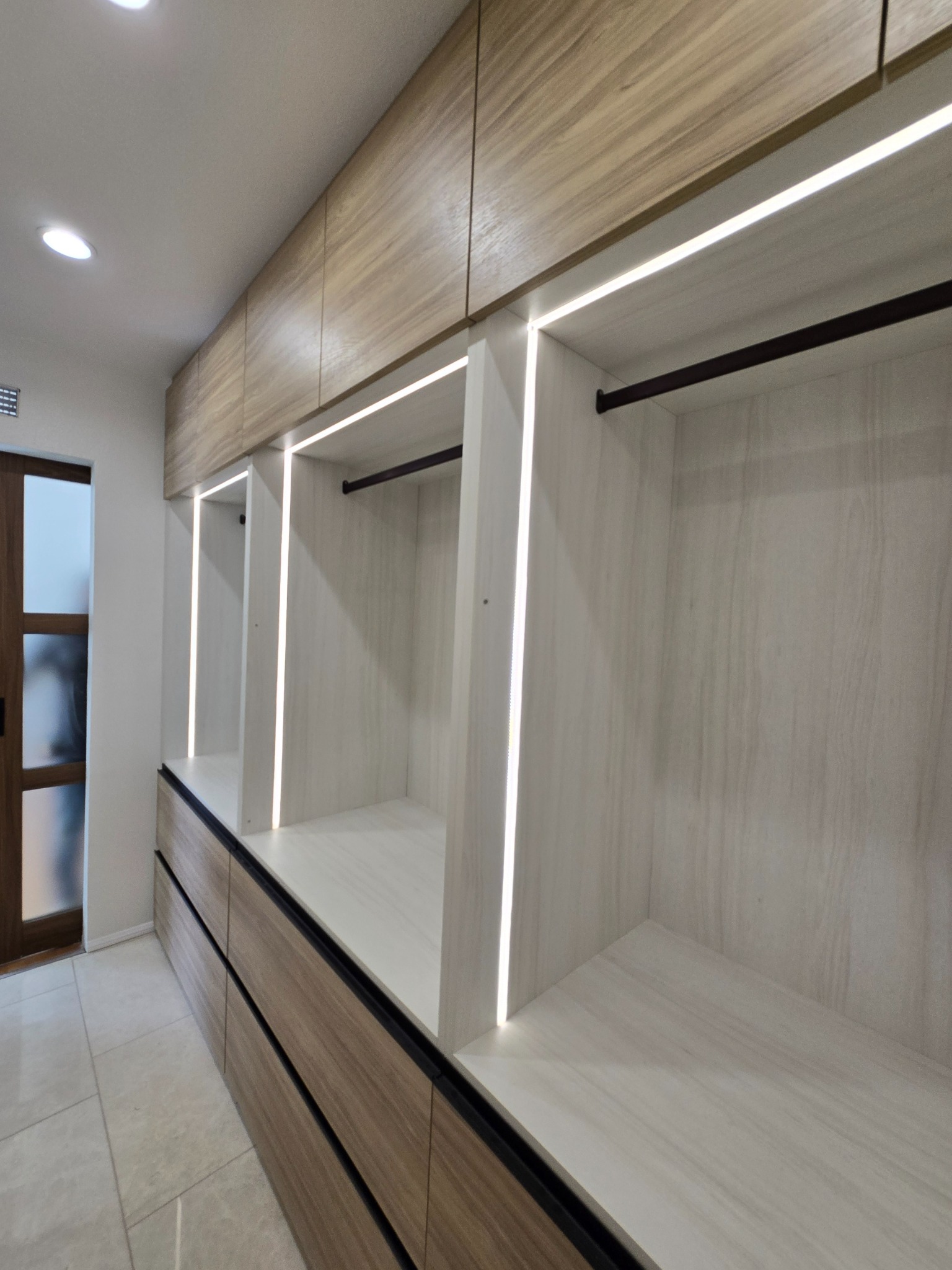 Custom closet with vertical LED accent lighting and double hanging.