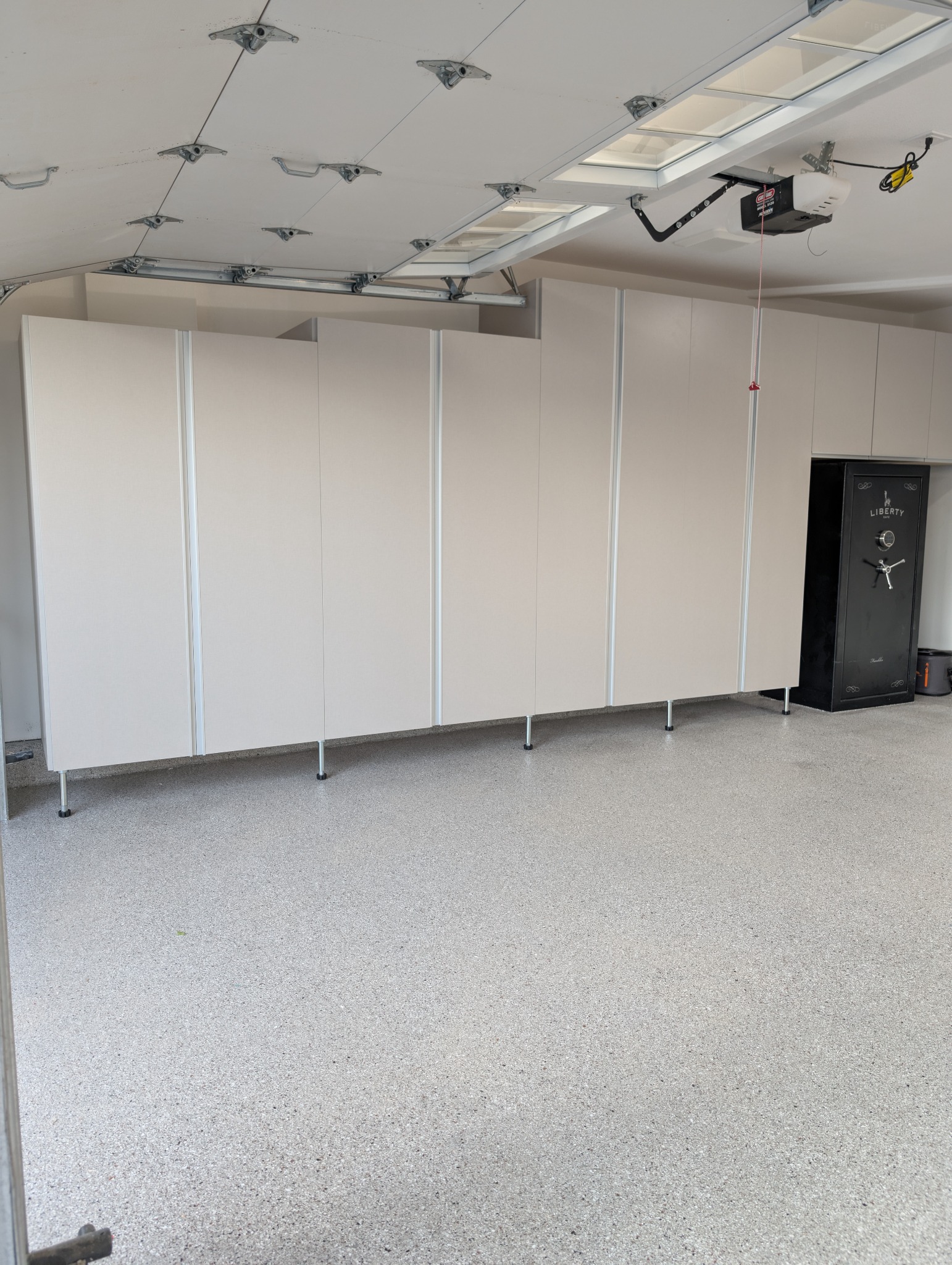 Full run of garage cabinets on legs with aluminum trims.