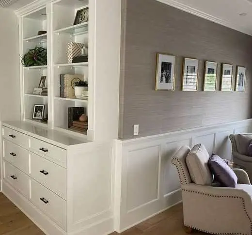 Custom white built-in cabinetry with open display shelving and drawer storage below