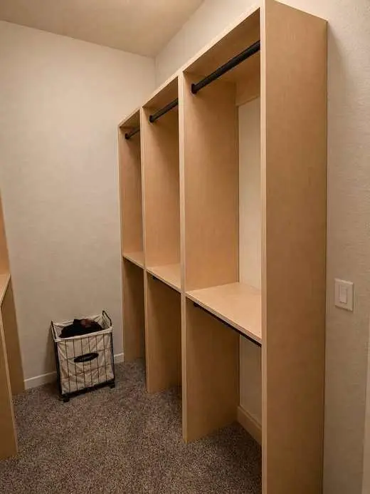 Custom natural oak closet with hanging rods and open shelving