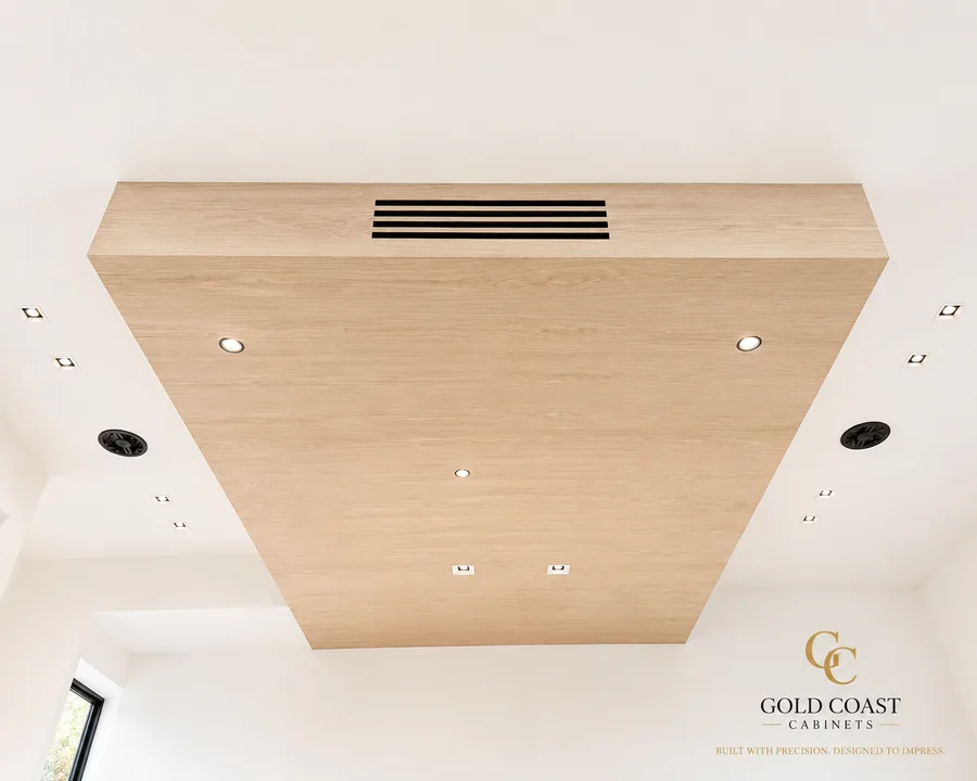 Custom white oak-finish ceiling soffit with a linear HVAC vent and integrated recessed lighting