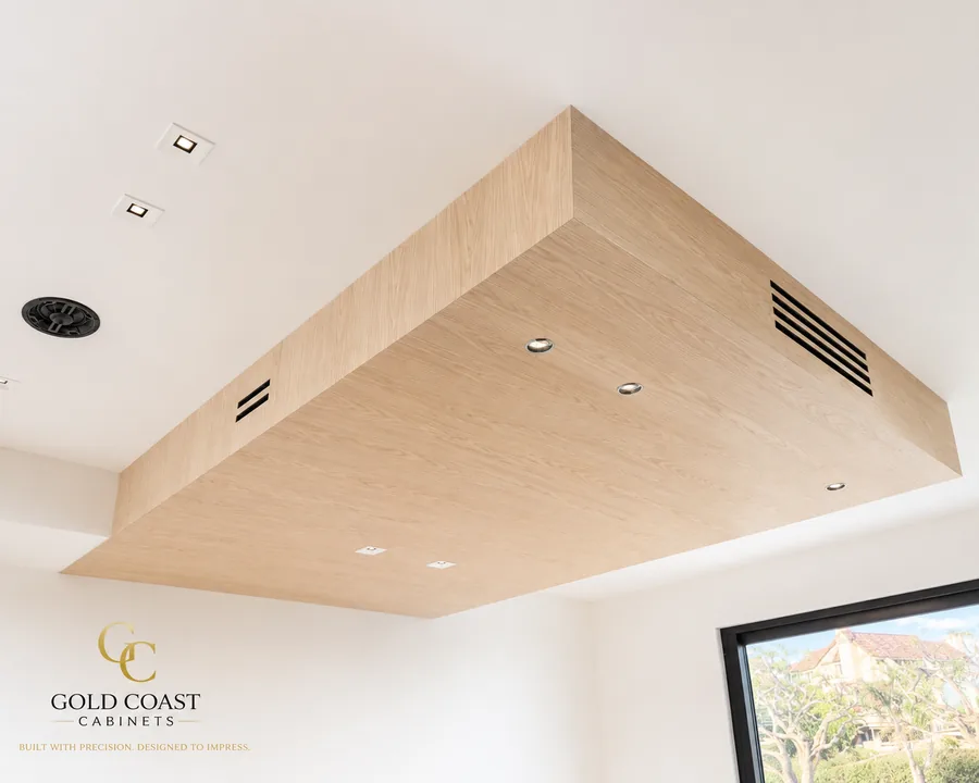 Custom white oak-finish floating ceiling soffit with integrated recessed lighting and linear HVAC vents