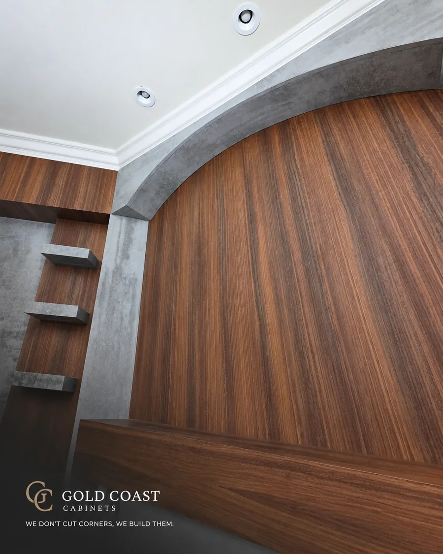 Arched walnut-tone paneling framed in concrete-finish panels with floating shelves