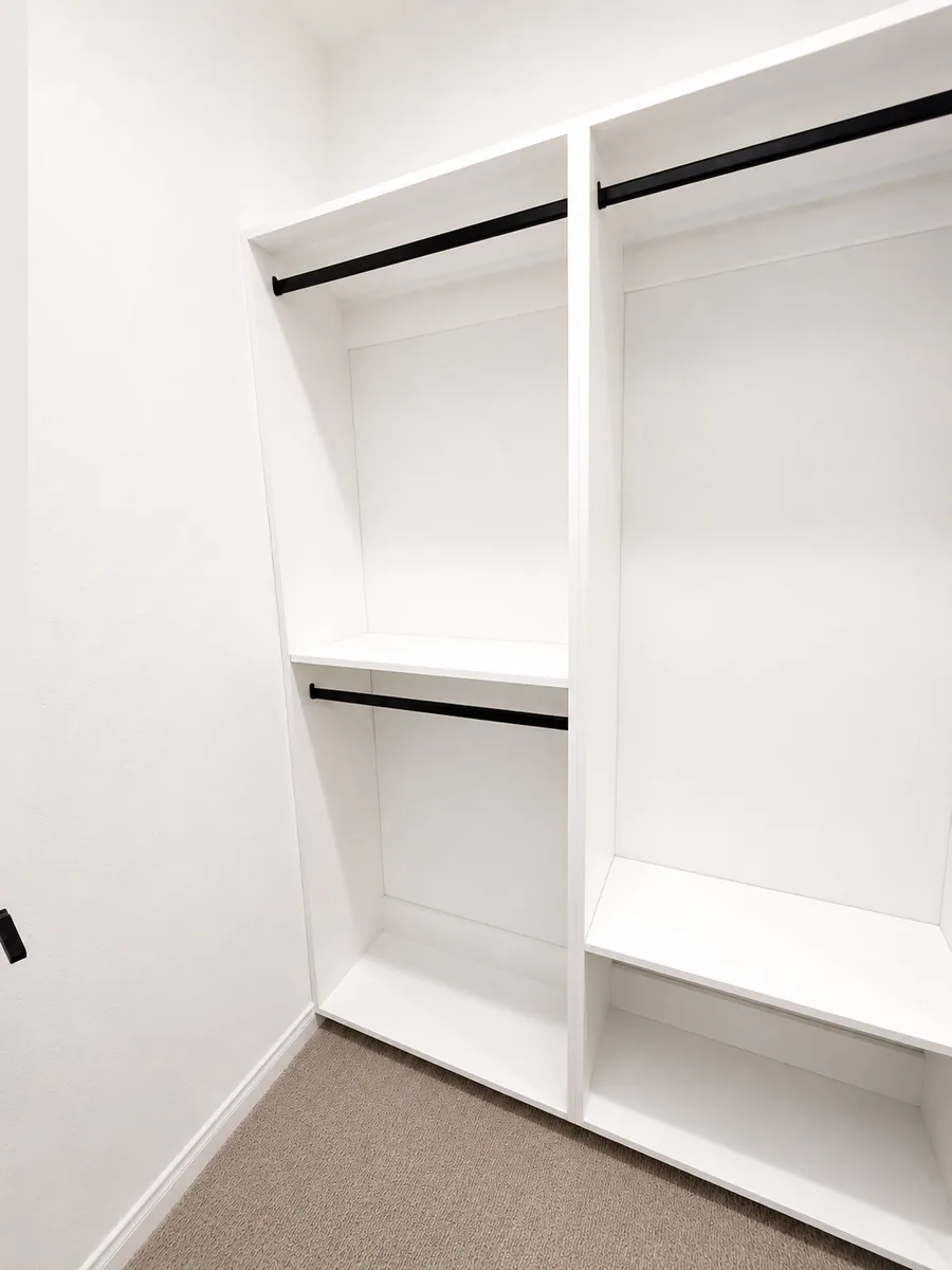Custom white closet with double hanging, long hanging, and matte black closet rods